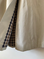 Close-up of beige fabric with a checkered pattern at the edge on a white background