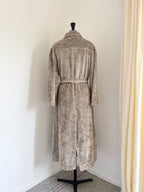 A plush, textured coat in a warm taupe-beige color, shown from the back on a black dress form mannequin.