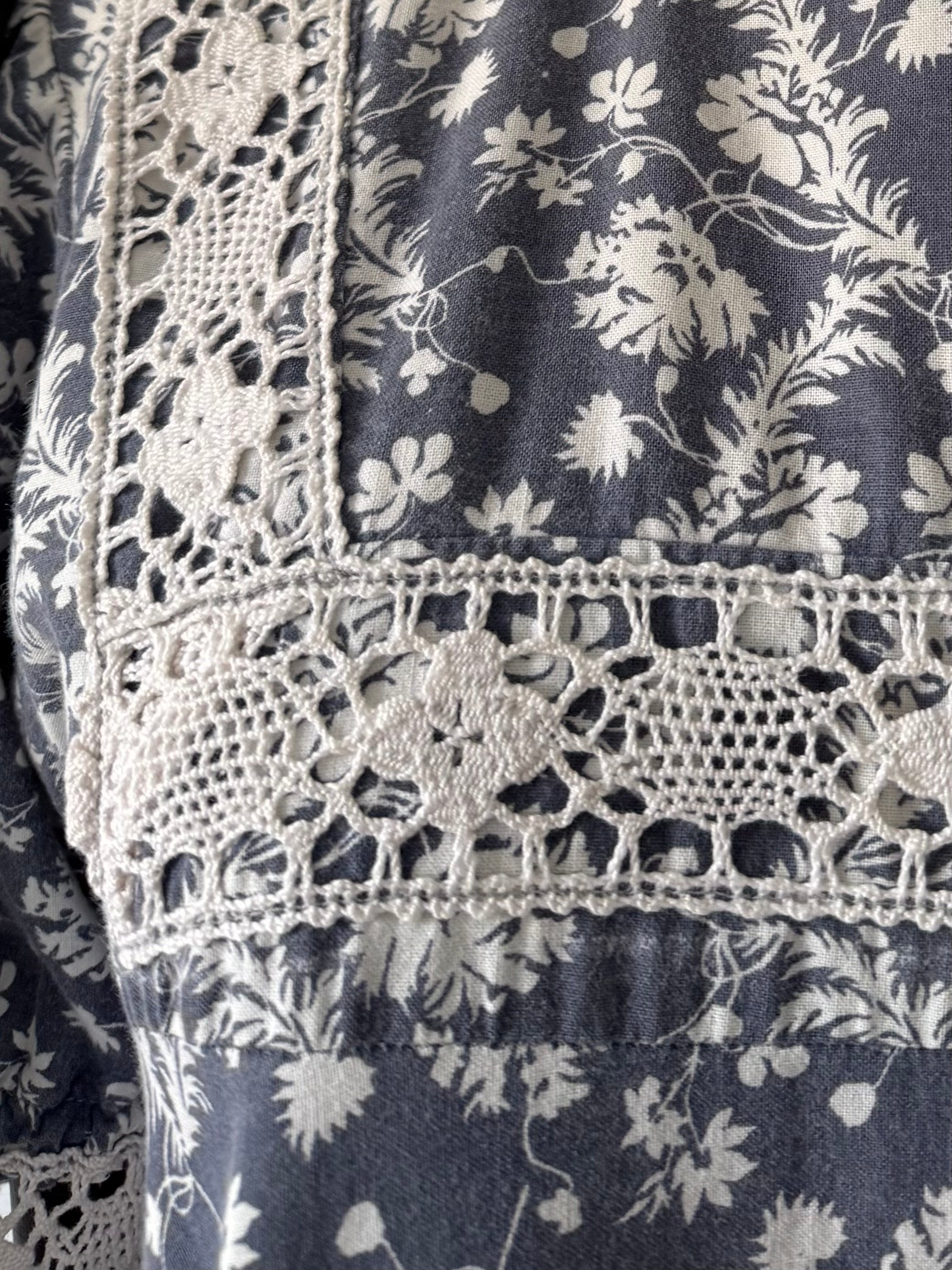 Close-up of a floral patterned fabric with lace trim on a dark background