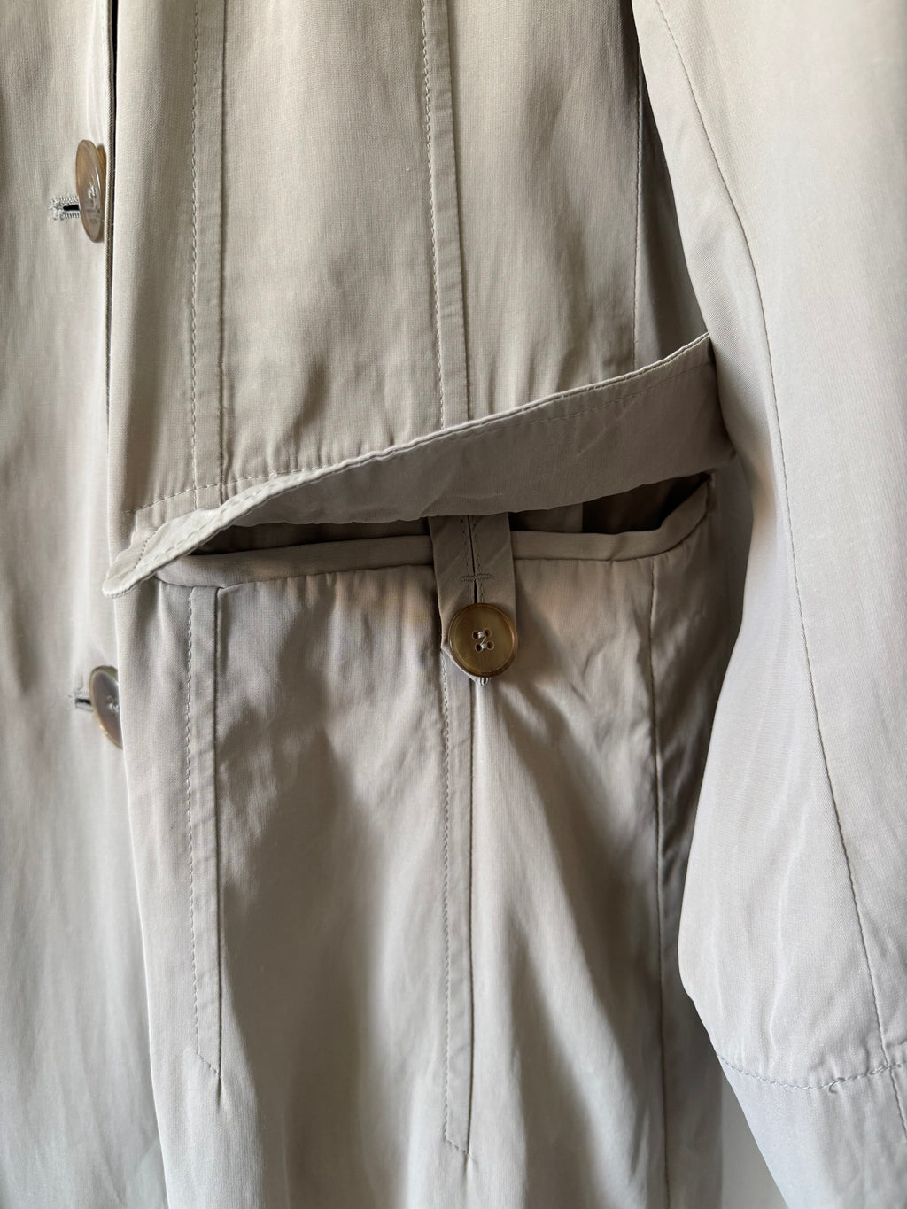 Close-up of trench coat with a button detail