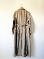 Long beige coat on a hanger against a white wall