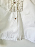 White blouse with lace detailing on a white background