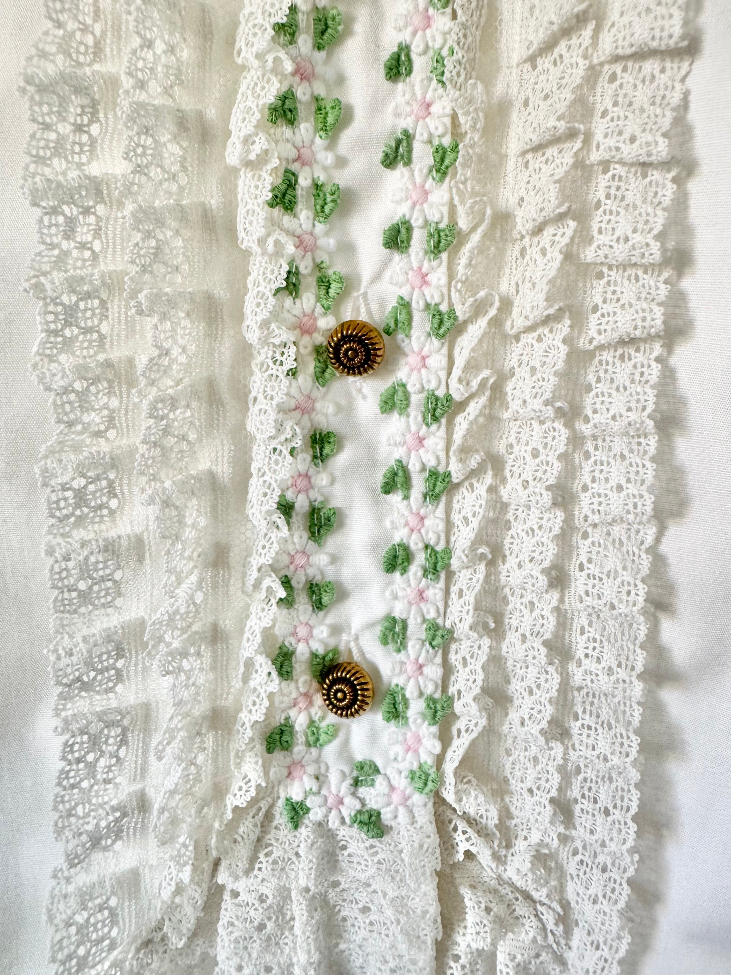 Decorative lace trim with floral patterns and buttons on a textured white background